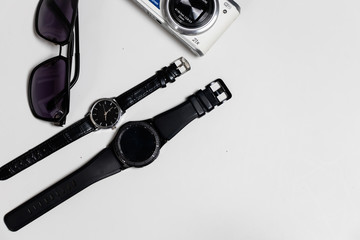 Top view women and man watch sunglasses and camera on flat lay