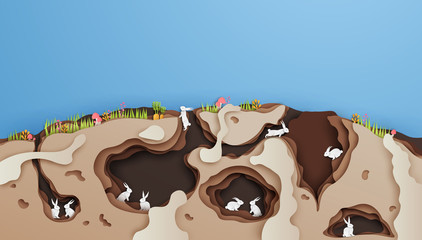 Illustration of rabbits and family living in the hollow of underground house. cross section of rabbit house in paper art style. paper cut and craft style. vector, illustration. © ibom