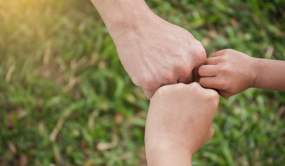 Family hands Giving Fist Bump. Successful business teamwork with hands gesture communication over green grass nature background. Family partnership business work strength together harmony concept