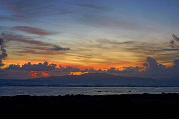 Dramatic sunrise view of the island and lagoon of Raiatea (Ra'iatea) near Tahiti seen from Bora Bora in French Polynesia, South Pacific