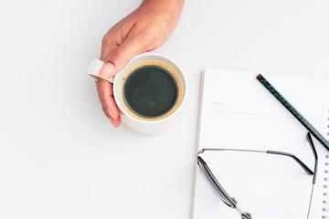Woman hand holding cup of coffee open notebook Flat lay