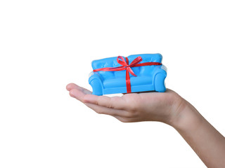 Blue sofa with red ribbon in baby's left hand isolated on white. Unusual gift.