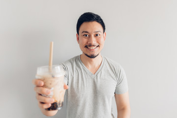 Happy man is drinking Bubble Milk Tea or Pearl Milk Tea. Popular Milk Tea in Asia and Taiwan.