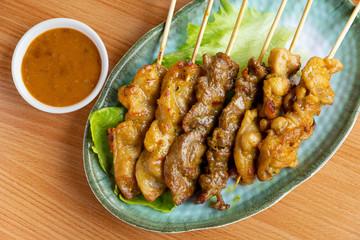 Six pieces of satay on a wood table