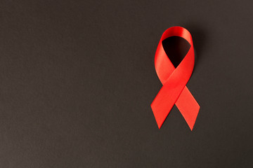 Red aids ribbon.  Isolated on black background with empty space for text.