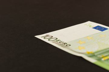 100 Euro banknote on a dark background. Close up. The concept of savings.