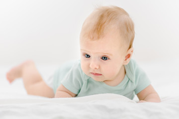 Portrait of cute newborn baby lying on belly at home
