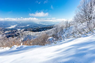 雪の斜面と雲上の乗鞍岳