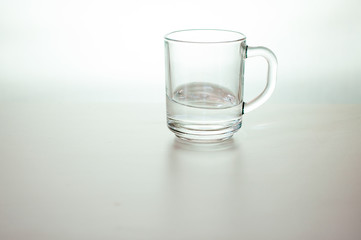 Water wave in transparent glass on gray background. purified fresh drink water on table