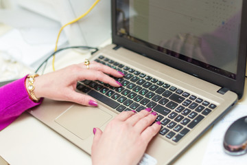 Close up of woman hands working with laptop in office