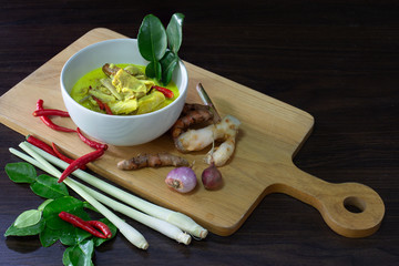 Ferment pork boil with coconut milk and young banana trunk Thai local food in white bowl on wooden chopping