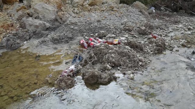 Small clean creek polluted with trash, conceptual footage of human negligence.