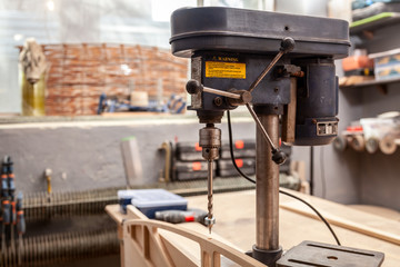 Industrial Iron drill ready for work in workshop interior. Close up on the drilling machine
