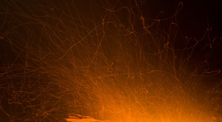 Burning fire in the night. Flame and fire sparkles on a dark abstract background. Hellish element of fire. Fuel, power and energy