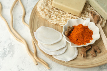 Home beauty products - turmeric, soap, scrub, sponges, soap, facial brush on light background, top view. Skin youthfulness, wellness, spa beauty concept. Flat lay