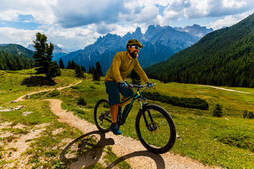 Single mountain bike rider on electric bike, e-mountainbike rides mountain trail. Man cycling on...