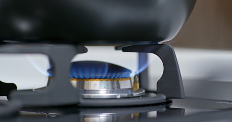 Fototapeta na wymiar Stove top burner igniting into a blue cooking