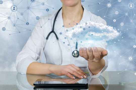 A doctor holding an information and data cloud above a tablet.