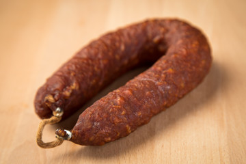 Luftgetrockneter Mettwurst Ring aus Schweinefleisch auf Holz Brett 