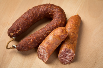 Luftgetrockneter Mettwurst Ring und frische Bierbeißer, zwei Salami Sorten aus Schweinefleisch auf Holz Brett 