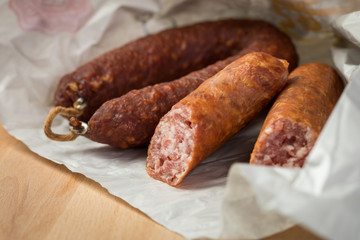 Ringwurst Salami und Bierbeißer Wurst in Wachspapier auf Vesper Holzbrett