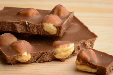 Close-up photo of delecious chocolate with nuts laying on wooden table