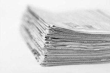 Pile of old newspapers on white background. Black and white photo.