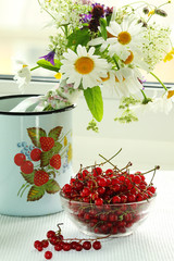 A bouquet of wildflowers and a glass bowl of red currant