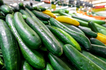 Vegetable background, fresh and shiny organic zucchinis or courgettes on a local food market, Bali island.