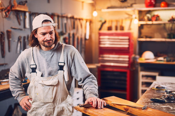 Male carpenter fixing old wood in a retro vintage workshop.