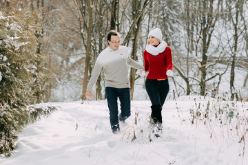 Fototapeta na wymiar Happy Couple Having Fun Outdoors in Snow Park. Winter Vacation