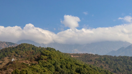 Fototapeta na wymiar Clouds over Mountains, Landscape in the mountains, View from the Indrunag, Dharmashala, Himachal Pradesh, India.