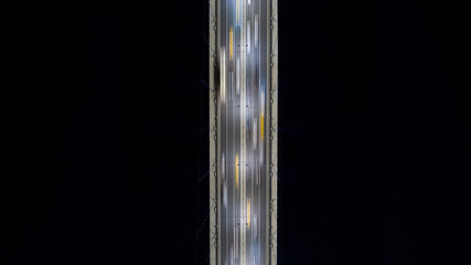 Aerial view of cars driving on bridge road at night. Long exposure photo of traffic. Transportation Icons. 