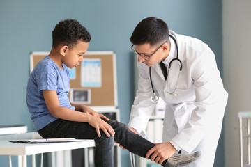 Pediatrician examining African-American boy in clinic