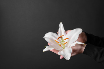 Woman with funeral lily on dark background