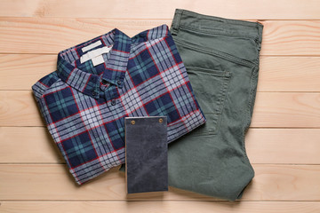 Male clothes with notebook on wooden background