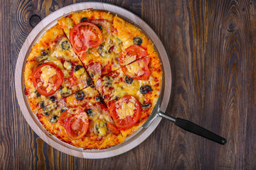 Tasty pizza and cooking ingredients tomatoes basil on wooden background. Top view of hot pizza. With copy space for text. Flat lay. Banner