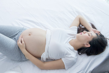 Portrait of Beautiful young pregnant woman in her bedroom.Pregnancy health care preparing for baby concept.Motherhood among teenage mother.