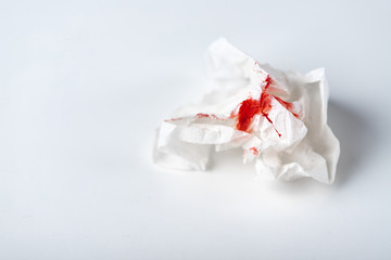 A photo of used bloody toilet paper on the light blue background