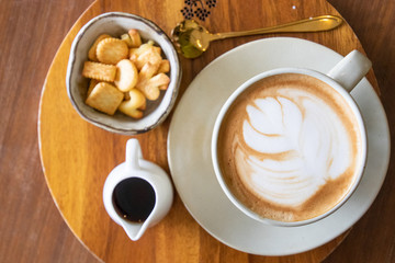 Coffee cup with latte art foam on wood table in coffee shop with copy space.Coffee is one of the most popular beverages.Improve Energy Levels and Burn Fat