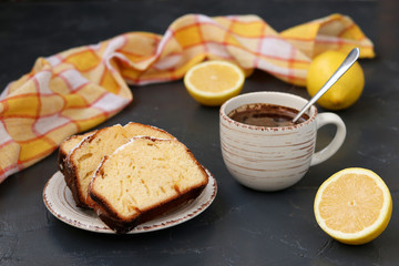 lemon muffin arranged on a plate against a dark background with a cup of coffee in the background