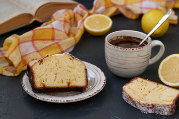 lemon muffin arranged on a plate against a dark background with a cup of coffee in the background