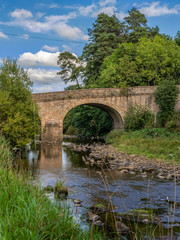Fototapeta na wymiar Stone bridge over the River Derwent in Blanchland, Northumberland, England, UK