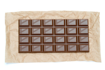 milk chocolate bar on craft packaging paper isolated on white background with clipping path