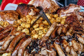 Sausages and meat greasy with onions and potatoes