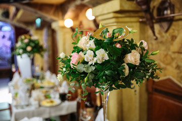 Wedding flowers standing on the table. Decoration details. Reception at the restaurant.