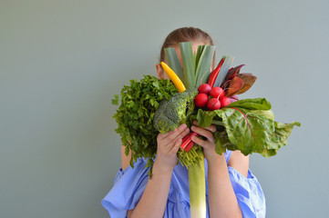 Girl holding vegetable bouquet in front of face