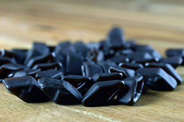 Salty liquorice candy on wooden table. Salmiakki (in Finnish) is popular across Finland and other Nordic countries.