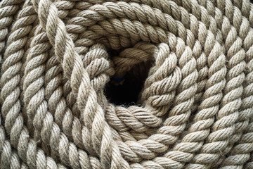The thick rope twisted in a roll. The top view on a rope spiral. The rope curtailed into a circle