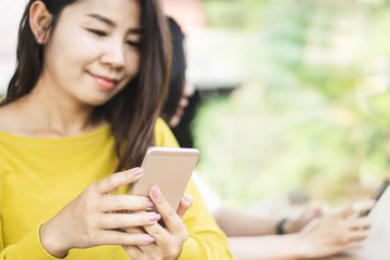 Fototapeta premium attractive Asian woman using smart phone outdoors in cafe 